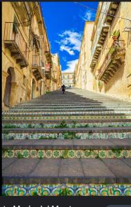 um grupo de escadas com flores num beco em casa vacanze Nonna Maria em Caltagirone