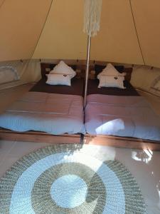 a tent with two beds and a glass table at Lainkalogos glamping in Rabia