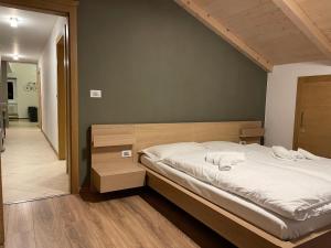 カヴァレーゼにあるMansarda Ciliegio Cavaleseのベッドルーム1室(ベッド1台、タオル2枚付)