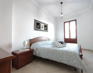 a bedroom with a bed and a table and a window at La Dimora del Viaggiatore in Jerzu