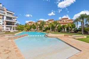 a swimming pool in front of a building at Luxusní apartmán ve Španělsku, Cabo Roig in Playas de Orihuela