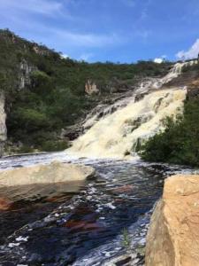 een uitzicht op een rivier met rotsen en een berg bij Pousada Riacho Doce - Curimataí - Buenópolis - MG in Curumatahy