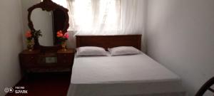 Un dormitorio pequeño con una cama y un espejo. en Desitha Family House, en Mirissa