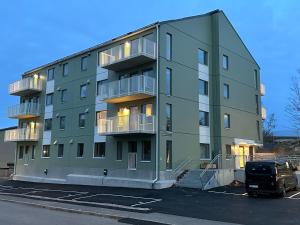 a green building with a van parked in a parking lot at Feels Like Home in Gothenburg