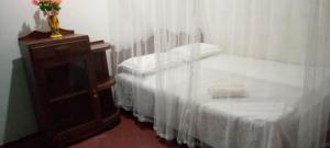 Un dormitorio con 2 camas y una mesa con un jarrón. en Desitha Family House, en Mirissa