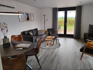 Vakantiewoningen Eyveld في بيسيل: غرفة معيشة مع أريكة وطاولة