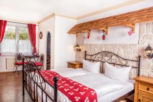 una camera da letto con un grande letto con una coperta rossa di Traditions-Gasthaus Bayrischer Hof a Leutkirch im Allgäu