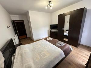 a bedroom with a large bed and a piano at Pensiunea Floro in Întorsura Buzăului