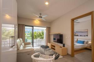 a living room with a couch and a television at Wonderful Mont Choisy flat, huge lagoon pool in Mont Choisy
