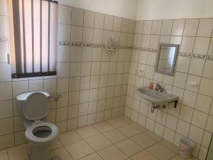La salle de bains est pourvue de toilettes et d'un lavabo. dans l'établissement Pioneerspark Self Catering, à Windhoek