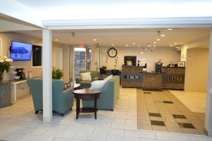 eine Lobby mit Stühlen, einem Tisch und einer Theke in der Unterkunft Copley Inn & Suites, Copley - Akron in Akron