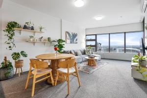 een woonkamer met een tafel en stoelen en een bank bij The Sky Garden in Sydney