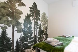 a bedroom with a forest mural on the wall at Fewo Eifel Eichen in Nideggen