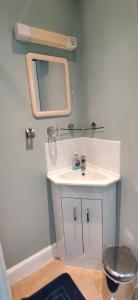 Un baño con un lavabo blanco y un espejo. en Royal Mile apt, just 1 min from Edinburgh Castle!, en Edimburgo 17 fotos más