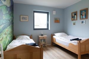 - 2 lits dans une chambre aux murs bleus dans l'établissement Fewo Eifel Eichen, à Nideggen