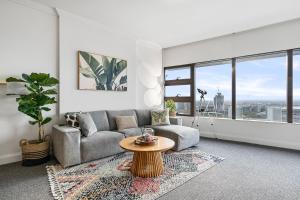 een woonkamer met een bank en een tafel bij The Sky Garden in Sydney