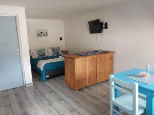Zimmer mit einem Bett, einem Tisch und einem TV in der Unterkunft SUOMI in Villa Pehuenia
