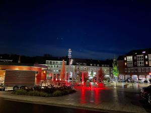 a city at night with a fountain and buildings at Rathausplatz Residenz in Übach-Palenberg