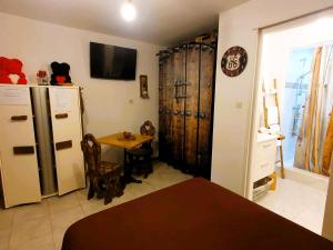 cocina con nevera y mesa con sillas en Studio 19 cosy avec jacuzzi et jardinet privatifs, en Draguignan
