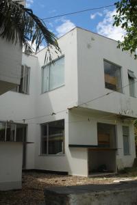 um edifício branco com janelas e uma palmeira em Mansion 16 em Medellín