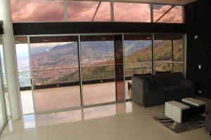 uma sala de estar com um sofá e uma grande janela em Mansion 16 em Medellín
