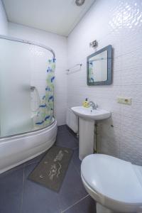 uma casa de banho com um WC, um lavatório e um chuveiro em Окремі номери поруч з Південним вокзалом em Carcóvia