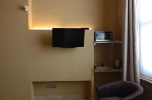 Habitación con TV en la pared y silla en Petit Pals, en Pals
