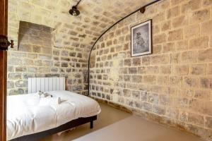 um quarto com uma parede de tijolos e uma cama em Nouveau - Industrial Appartement - 6p - Gym/Sauna em Paris