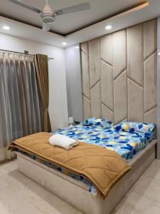 um quarto com uma cama grande e uma grande cabeceira. em SUKIS SUITES em Bangalore