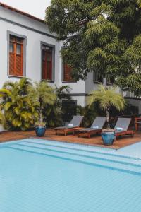 una piscina con 2 tumbonas junto a una casa en Casa de St. Antônio Hotel Boutique, en Parnaíba
