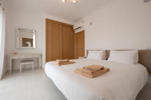 a white bedroom with a large white bed with towels on it at Porto de Mos 69 by Destination Algarve in Porto de Mós +48 photos
