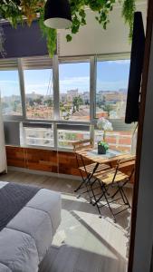 een slaapkamer met een tafel voor een groot raam bij Saltillo Alto Gray Studio. Vistas al mar y piscina in Torremolinos