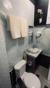 a bathroom with a toilet and a sink at Portville Mactan near Airport in Lapu Lapu City