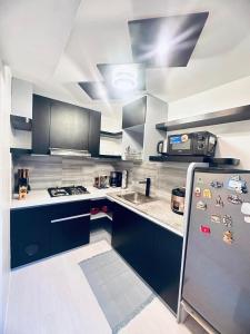 a kitchen with a refrigerator and a sink in it at Portville Mactan near Airport in Lapu Lapu City