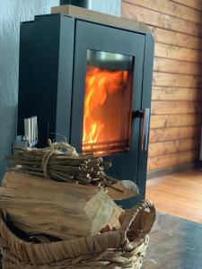 una stufa a legna con un fuoco in un cesto di Ferienhaus Auszeit a Lindenfels