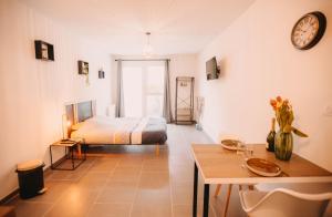 Un dormitorio con una cama y una mesa en una habitación. en Franc-Bisontin - Unique ! 4 logements disponibles, en Besançon