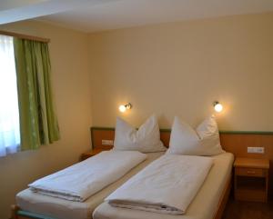 a bedroom with two beds with white pillows at Appartements Real in Schladming