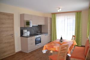 a kitchen with a table and a dining room at Appartements Real in Schladming
