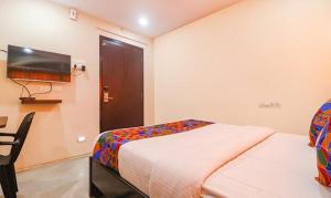 Schlafzimmer mit einem Bett, einem Schreibtisch und einem TV in der Unterkunft FabHotel LP MVP Colony in Visakhapatnam