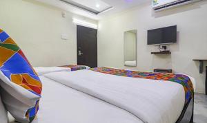 1 Schlafzimmer mit 2 Betten und einem Flachbild-TV in der Unterkunft FabHotel LP MVP Colony in Visakhapatnam