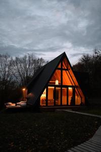 een klein houten huis met een zwart dak bij Cabana A-frame Cricov 9 in Valea Lungă-Ogrea