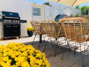 eine Terrasse mit einem Tisch und Stühlen sowie gelben Blumen in der Unterkunft Ferienhaus Visselheide in Visselhövede