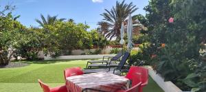 een tafel en stoelen in een tuin met een gazon bij Villa Clara in San Sebastián de la Gomera