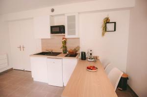 uma cozinha com um balcão de madeira e armários brancos em Franc-Bisontin - Unique ! 4 logements disponibles em Besançon