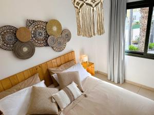 a bedroom with a bed and some plates on the wall at Villa Rosa Fuerteventura in Corralejo