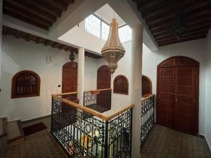 un corridoio di una casa con porte in legno e lampadario pendente di Riad ouhmidi a Marrakech