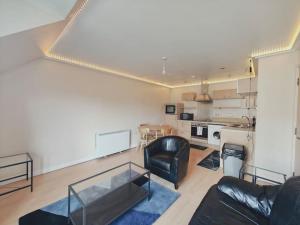 a living room with a leather couch and a table at Barking 1 bed flat With Parking in Barking