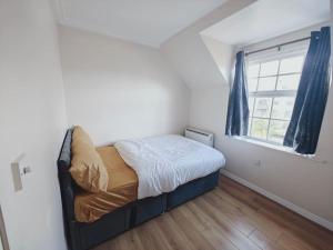 ein kleines Schlafzimmer mit einem Bett und einem Fenster in der Unterkunft Barking 1 bed flat With Parking in Barking