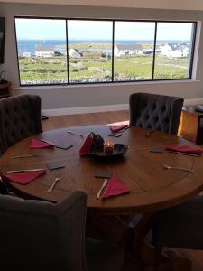 un tavolo in legno in una stanza con sedie intorno di Inis Mor, Aran Islands Luxury 5 bedroom with Seaviews 
