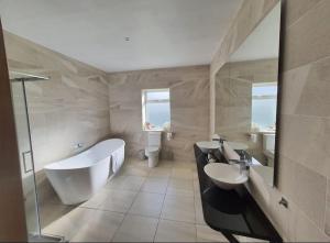 a bathroom with two sinks and a tub and two sinks at Inis Mor, Aran Islands Luxury 5 bedroom with Seaviews 
